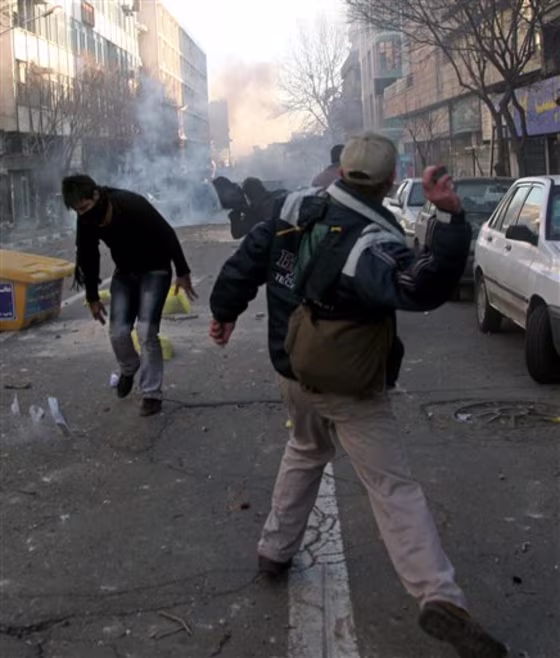 This photo, taken by an individual not employed by the Associated Press and obtained by the AP outside Iran, shows Iranian protesters throwing stones at anti-riot police Monday&nbsp;during an anti-government protest in Tehran, Iran.